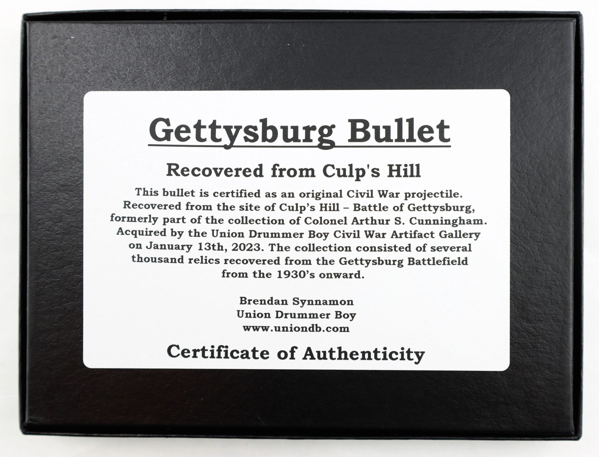 A certificate of authenticity for the Original Bullet Recovered from Gettysburg Culp’s Hill, detailing its history and acquisition, displayed in a black frame.