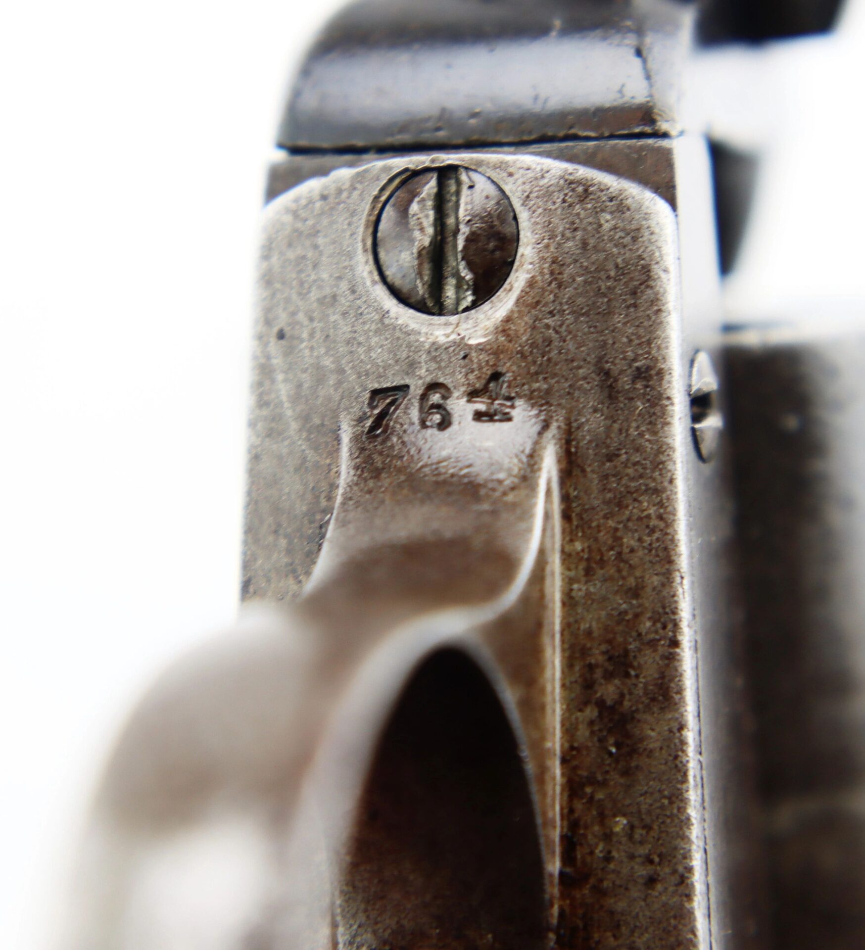 Close-up of a J. M. Cooper Pocket Model Revolver with a screw and the engraved number "764" on its metallic surface.