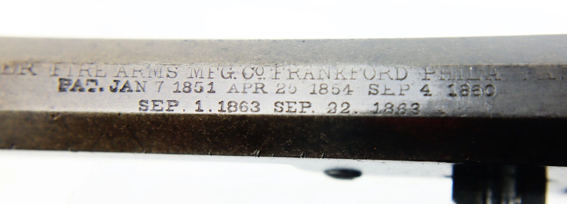 Close-up of the J. M. Cooper Pocket Model Revolver's metal barrel engraved with patent dates: JAN 7 1851, APR 26 1854, SEP 4 1860, SEP 1 1863, and SEP 22 1863. / SOLD.