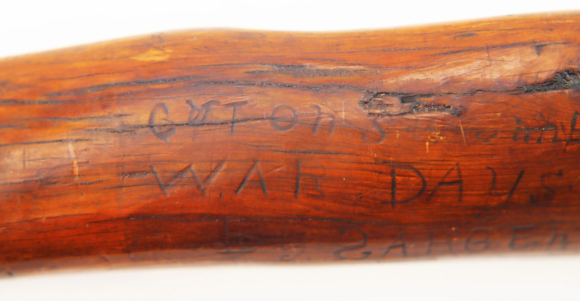 A close-up of carved words, "WAR DAYS," on the Cane Made of Wood from Georgia Swamp, with partial text also visible.