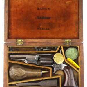 A Cased Model 1855 "Root" Revolver c. 1861 displayed in an open wooden case with a wooden-grip revolver, powder flask, bullets, a tin container, and assorted gun accessories arranged in compartments.