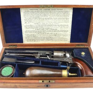 Open wooden case displaying a Cased London Colt 1851 Navy Percussion Revolver with bullet mold, powder flask, cap tin, cleaning rod, and loading/cleaning instructions inside the lid.