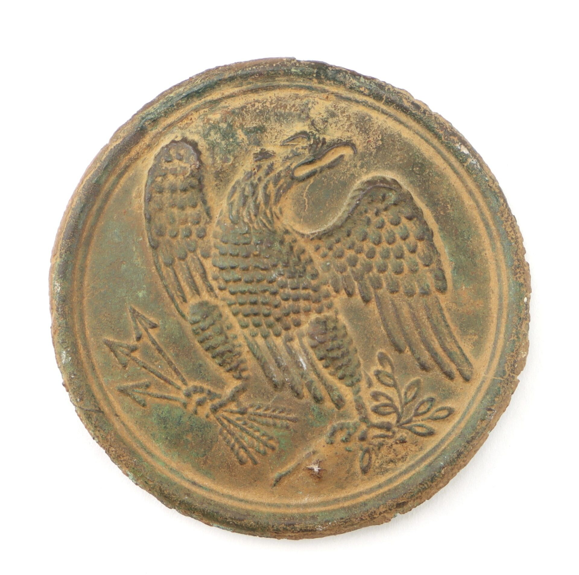A Gettysburg Eagle Breast Plate, a round aged metal medallion embossed with an eagle holding arrows and an olive branch. / SOLD.