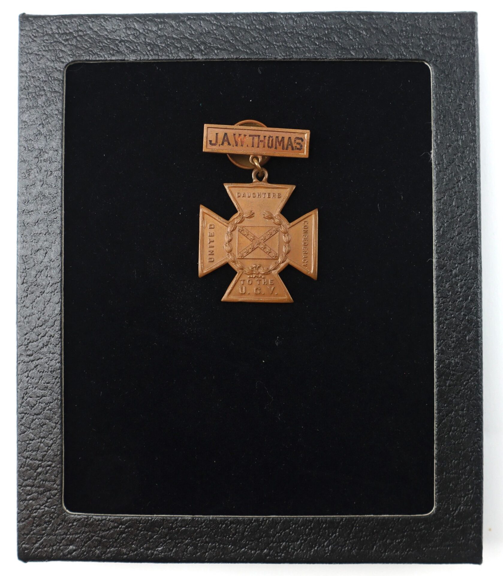 A bronze Southern Cross of Honor awarded to Captain J.A.W. Thomas, 21st South Carolina Infantry, Twice Wounded Confederate Officer, displayed on a black background in a black case.
