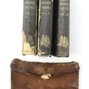 Three worn volumes of "Casey's Infantry Tactics" from the 10th Tennessee Volunteer Infantry (Union) Grouping stand upright, with a weathered brown leather case displayed in front of them against a white background.
