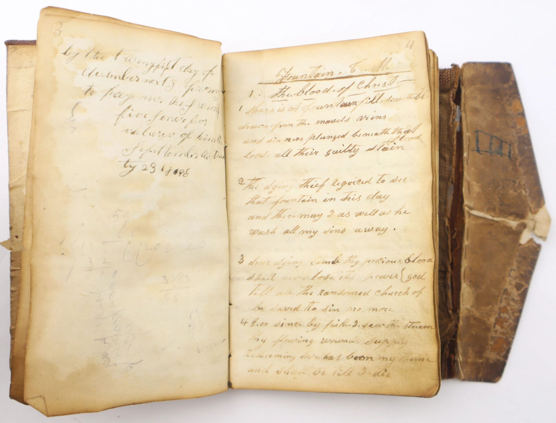 An old, worn book from the 10th Tennessee Volunteer Infantry (Union) Grouping is open to handwritten pages with faded religious notes and a list titled "Questions To All," its tattered brown cover hinting at its age.
