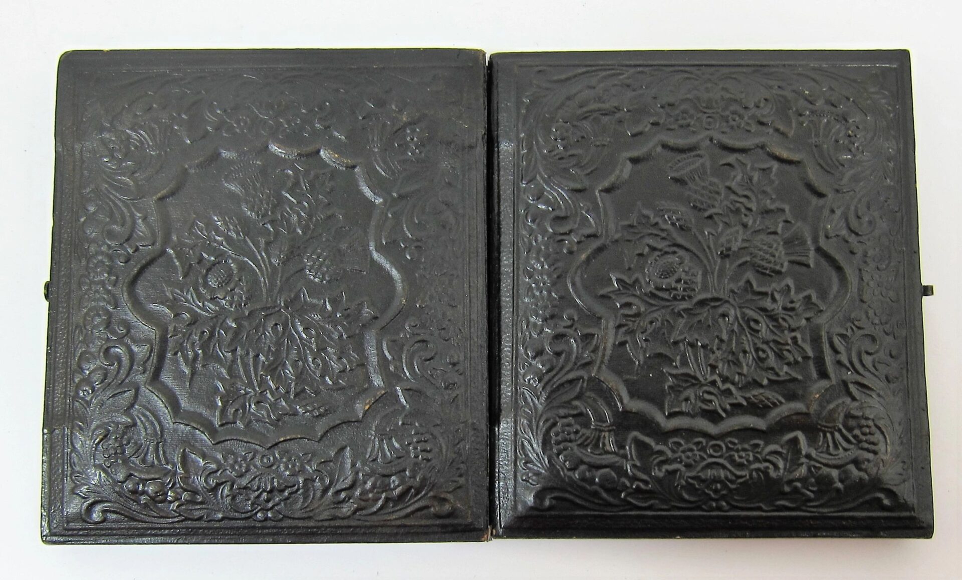 A closed, ornate black case with embossed floral designs holds the "Soldier with Model 1816 Musket Sixth Plate Tintype," displayed against a plain white background.