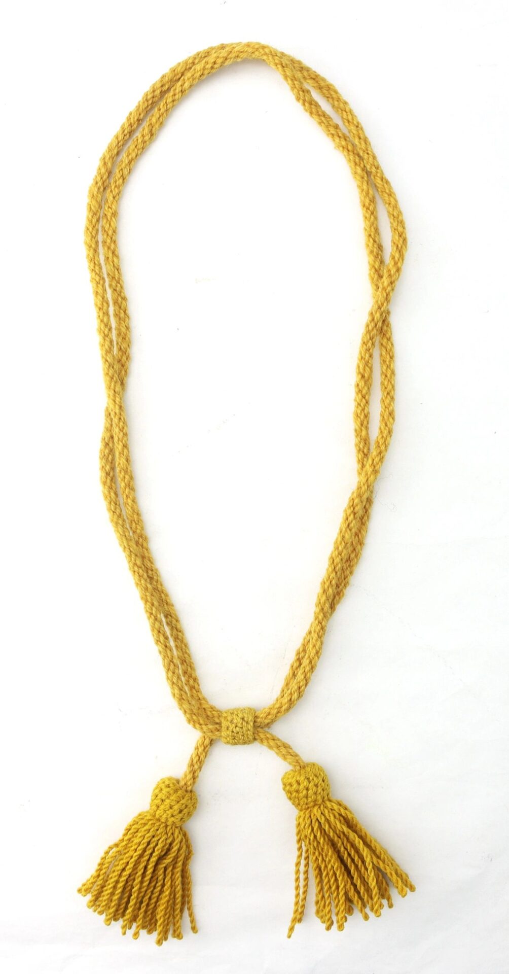 A Cavalry Hardee Hat Cord, yellow and braided with two tassels at the ends, is arranged in a loose loop against a white background.