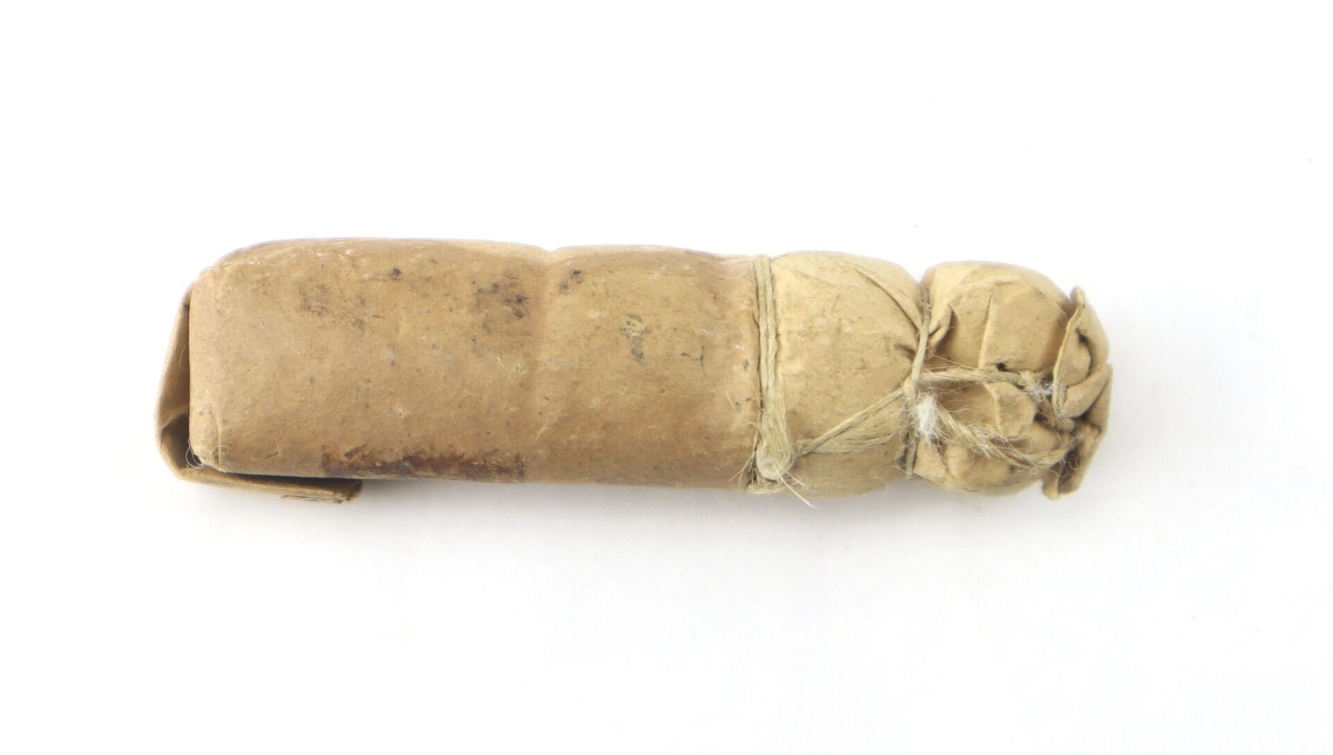 A Civil War .69 Caliber Buck & Ball Cartridge, wrapped in brown paper and tied with string, is displayed on a white background.