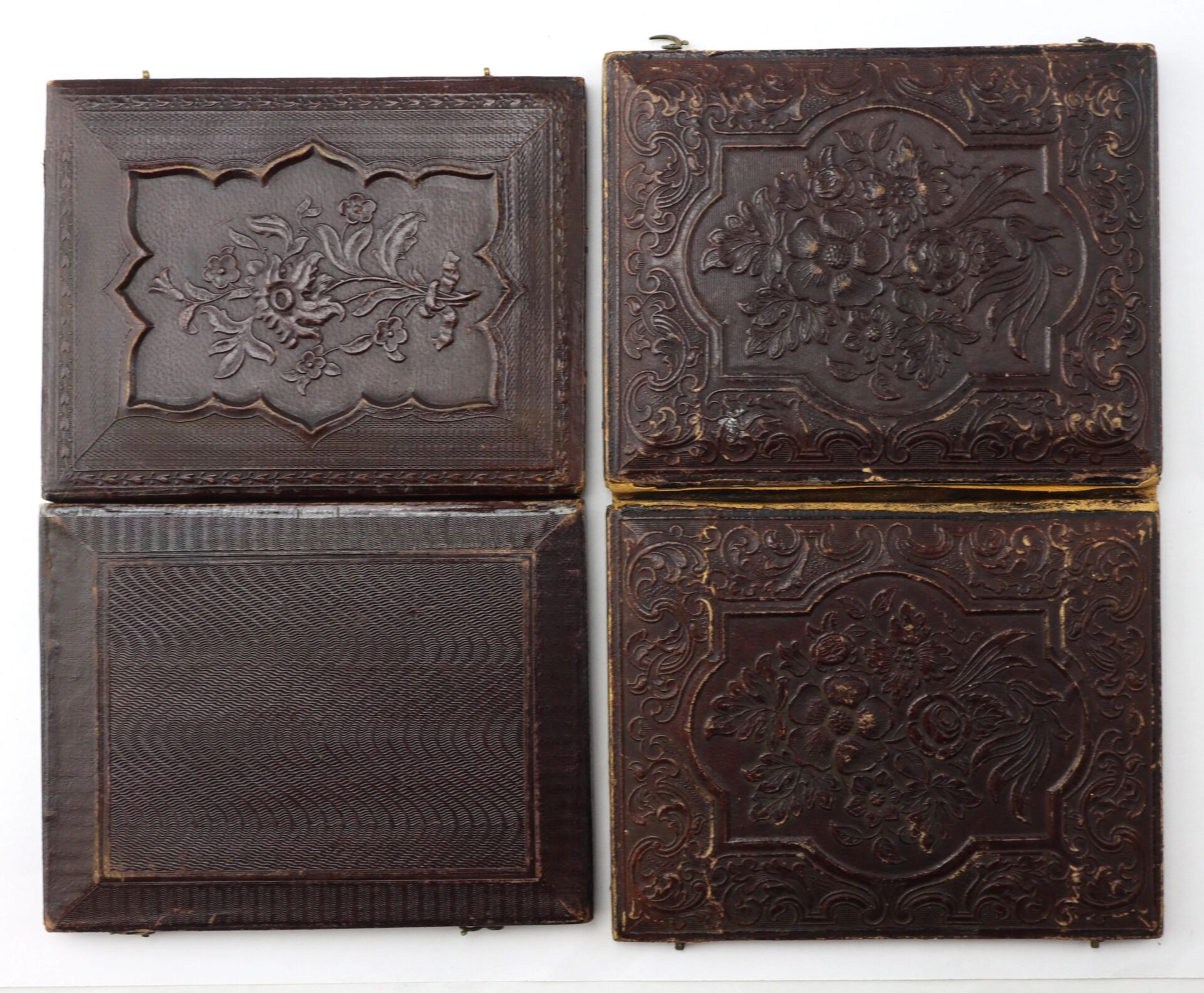 A 1/4 plate tintype of two Union musicians wearing Hardee hats displayed in an antique brown leather case with embossed floral and geometric designs, arranged on a white background.