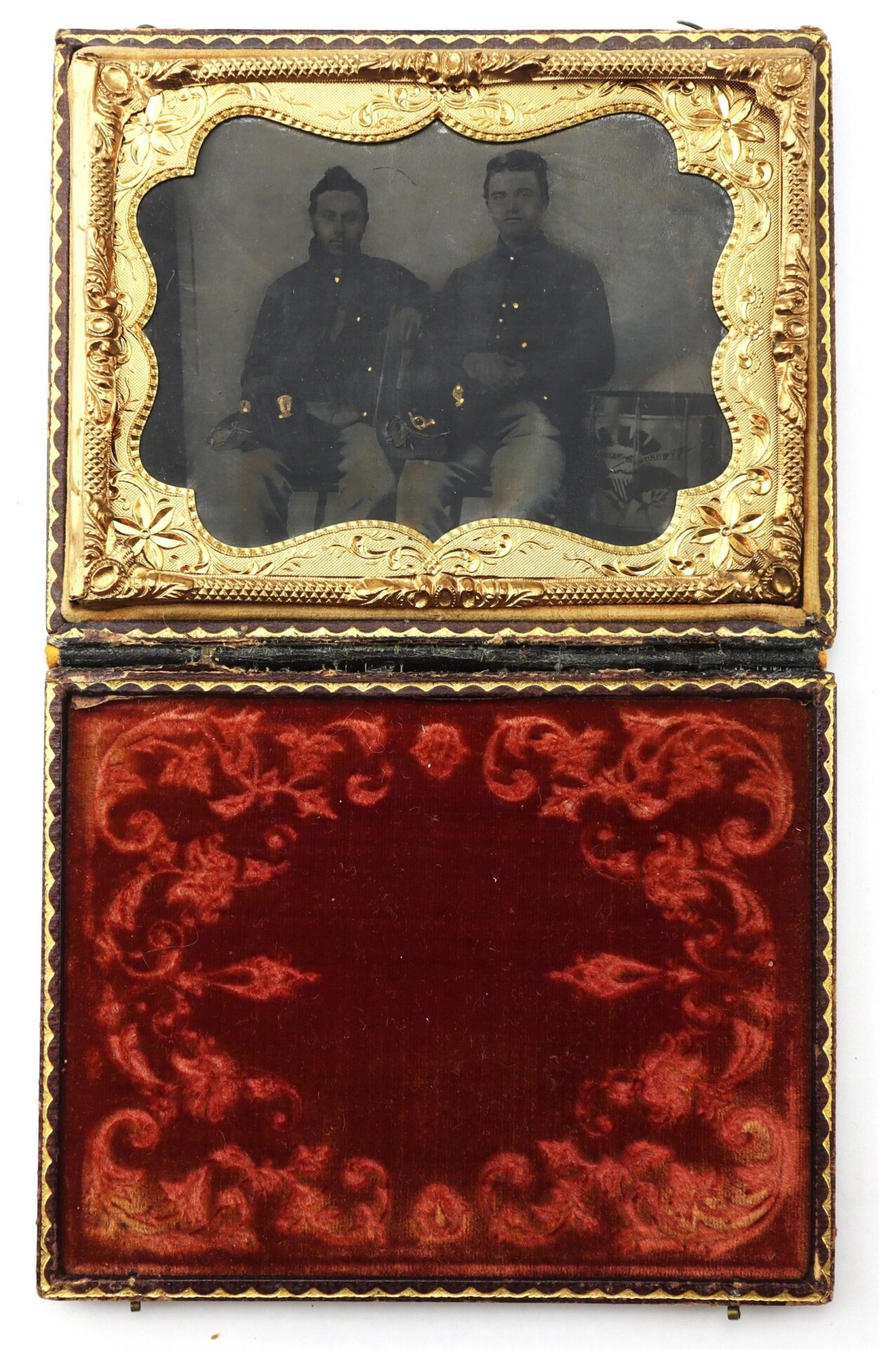 A 1/4 plate tintype of two Union musicians in Hardee hats, seated side by side in uniform, rests in an ornate gold frame with a red velvet-lined case open beneath the photo.
