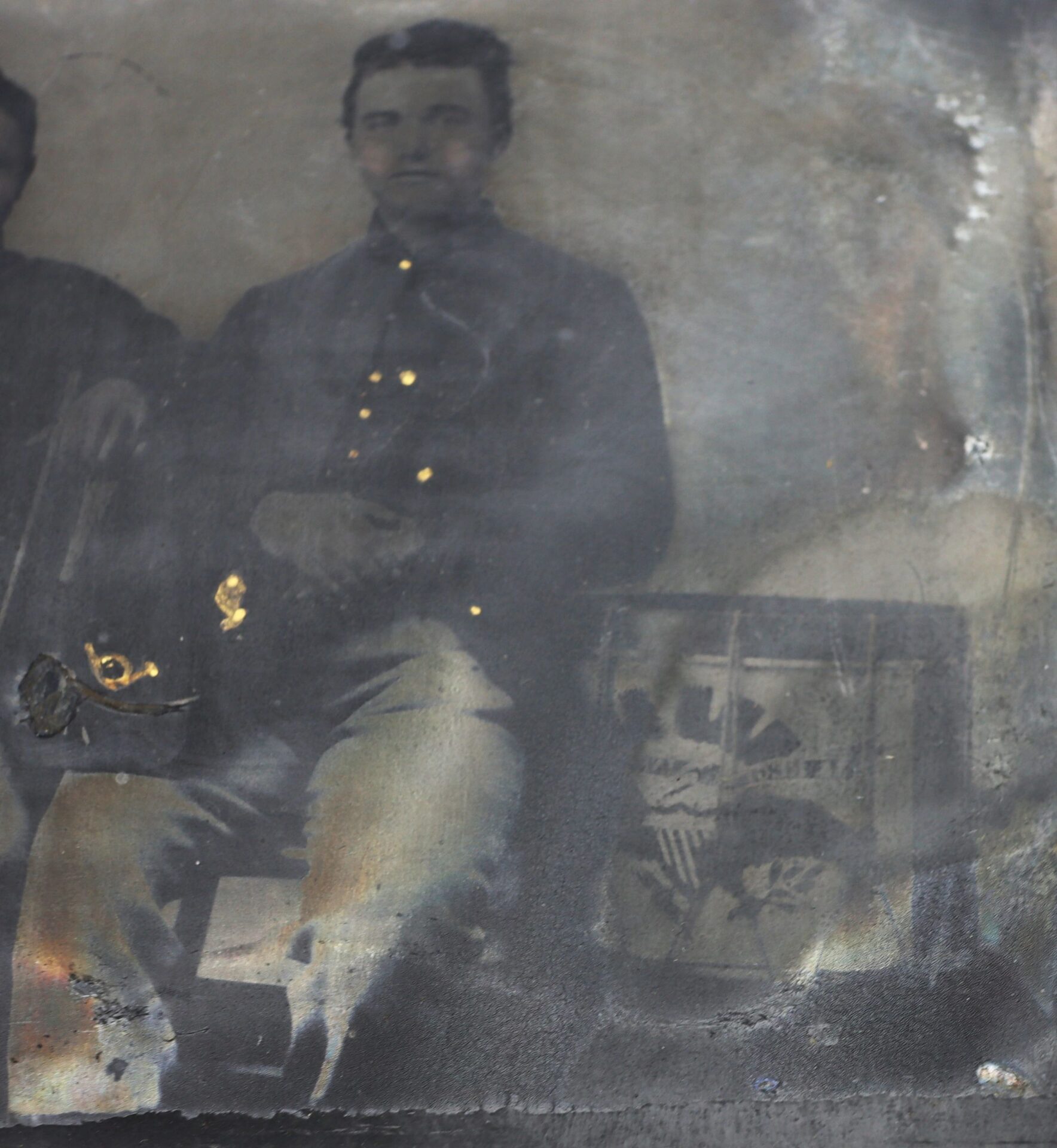 A 1/4 plate tintype depicts two Union musicians in Hardee hats, seated together; the sepia-toned photo shows some damage, with an old photograph or frame next to them.