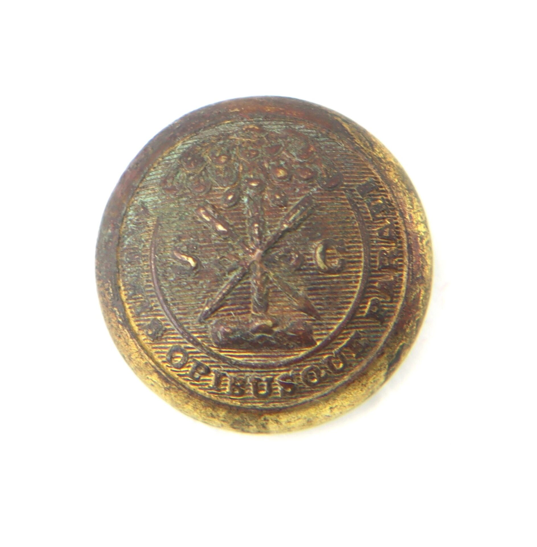 A round, worn brass Clark County Virginia Recovered South Carolina Vest Button with an embossed tree, crossed branches, "S" and "C" letters, and Latin text around the edge.