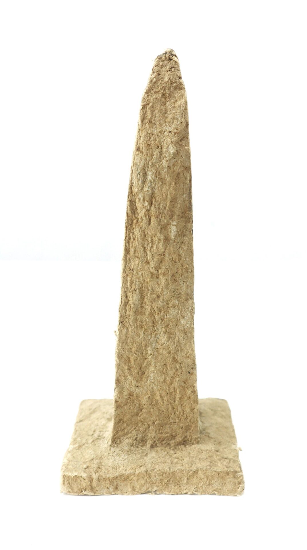 A rough-textured, upright, tapered stone-like object with a square base—Washington Monument made from macerated U.S. currency—photographed against a plain white background.