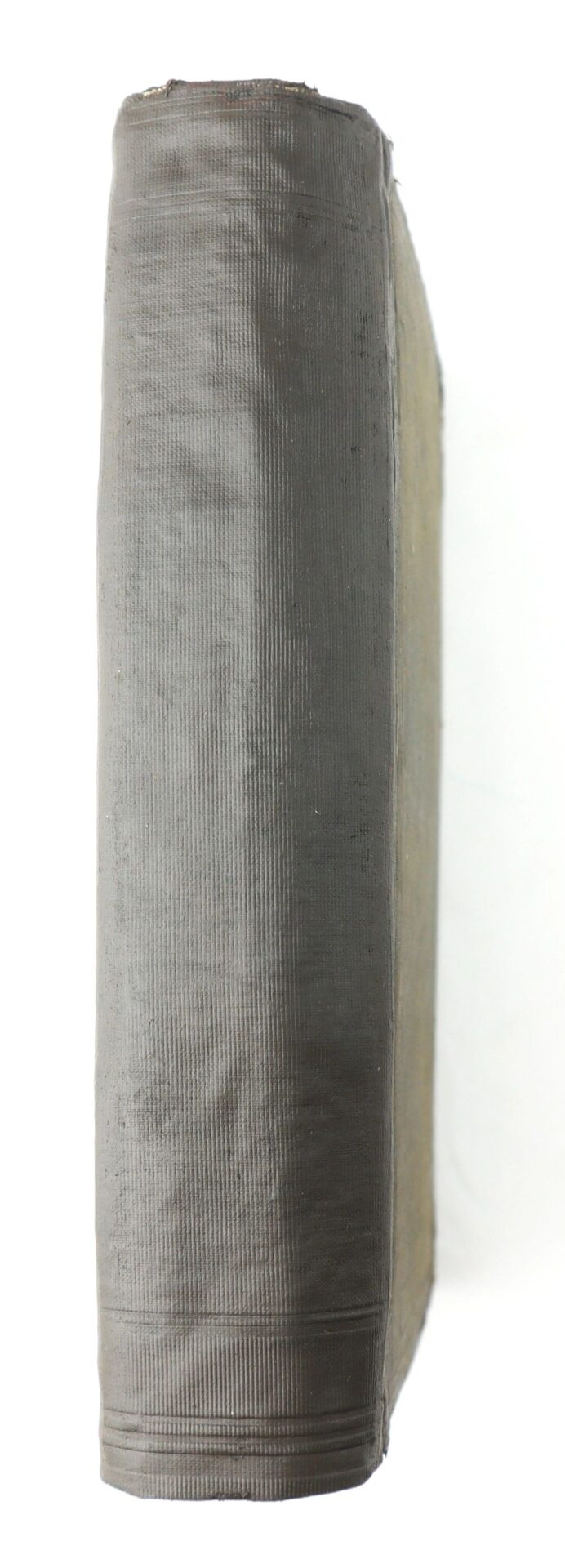 A close-up side view of the spine of "Fifty Years in Chains, The Life of an American Slave," a thick, vintage hardcover with a textured grayish cover and worn edges.