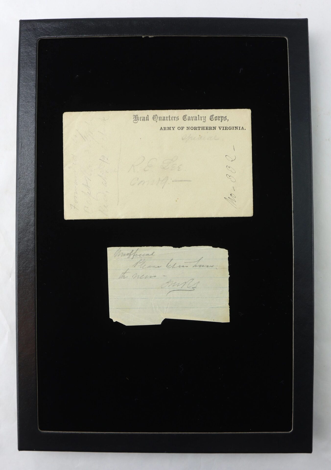 A framed display featuring Fitzhugh Lee’s hand-carried cover, addressed in pencil to "Gen. R.E. Lee Comdg:-," presented on a black background.