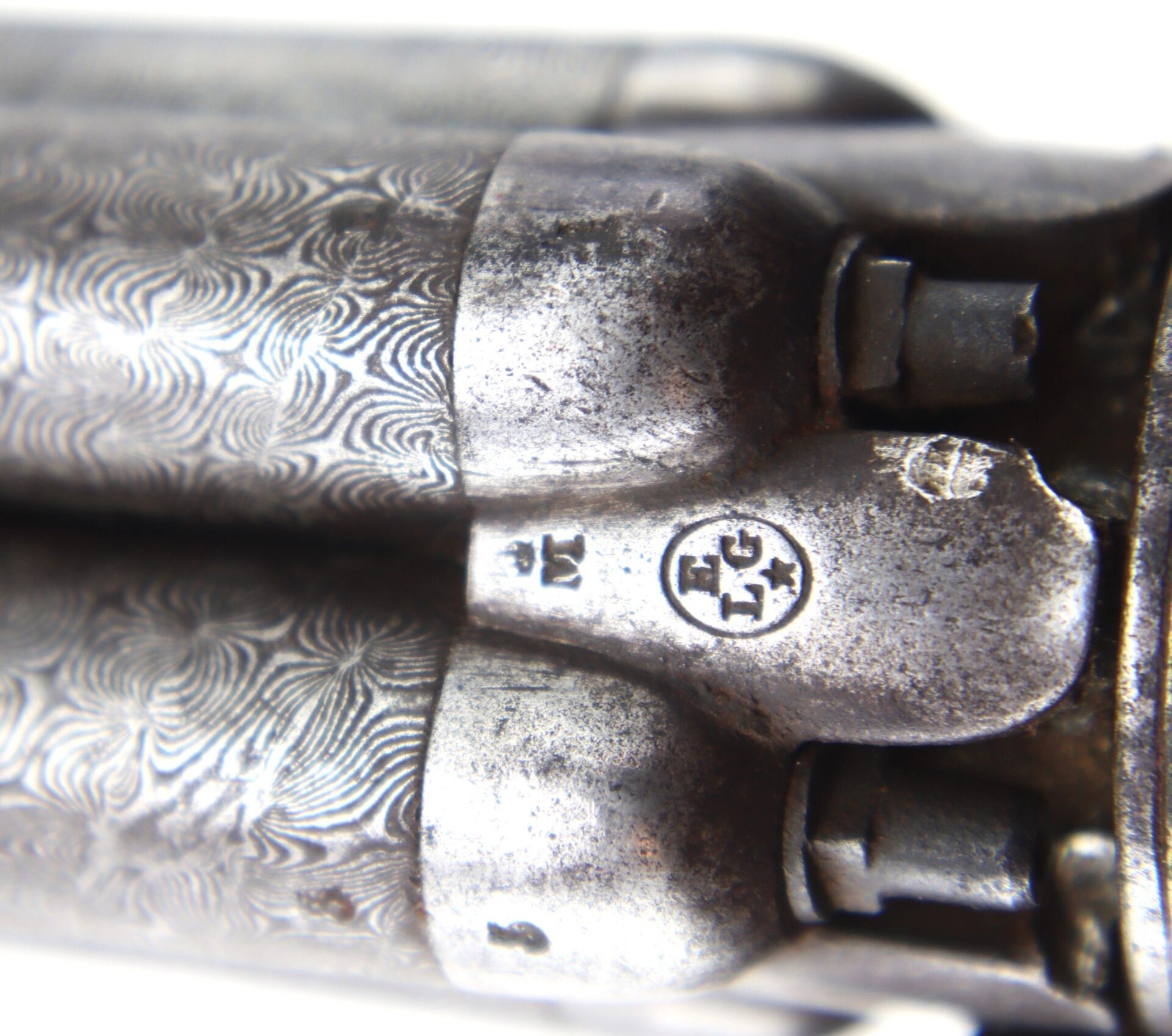 Close-up of the Five Barrel Pepperbox Revolver's metal barrels, featuring intricate engravings and proof marks stamped into the surface.