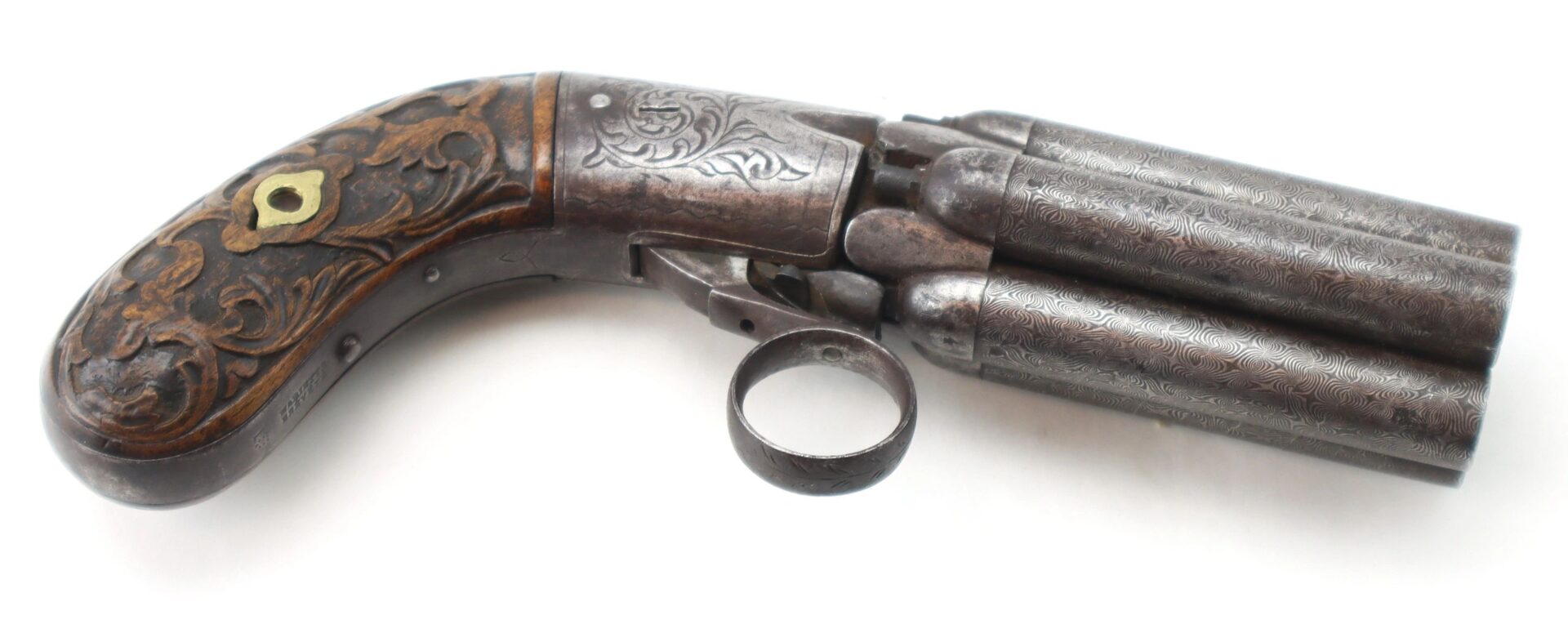 A vintage Five Barrel Pepperbox Revolver with ornate metal engravings and a decorative wooden grip, photographed on a white background.