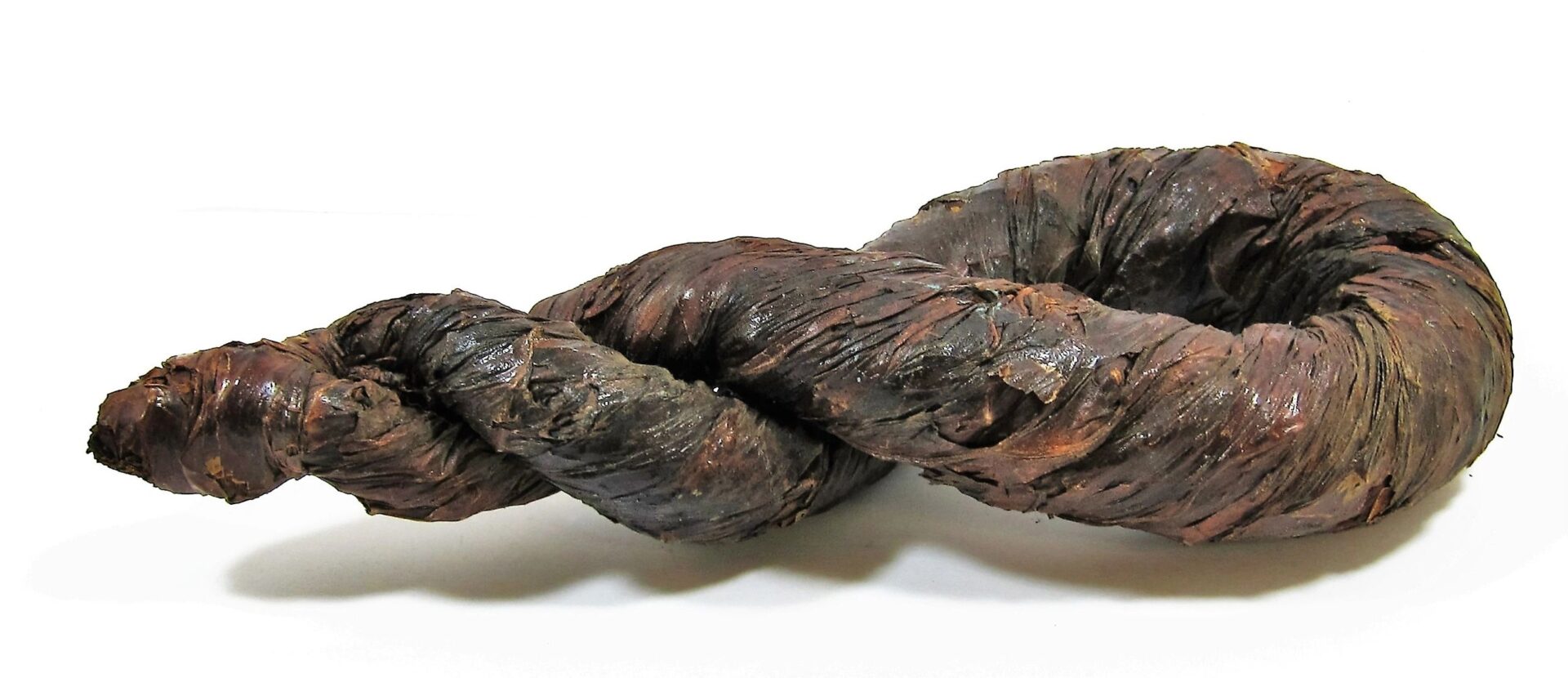 A large, dark brown Tobacco Twist, twisted and displayed on a white background.