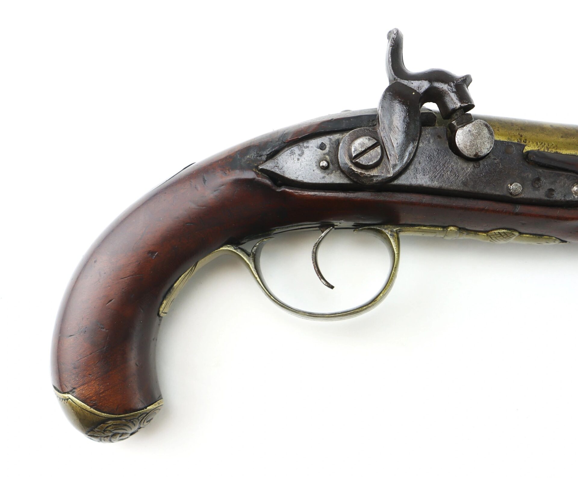 Close-up of the English Pistol with Brass Barrel and Grotesque Mask Butt Cap, featuring a wooden handle, metal trigger, and blackened lock mechanism on a white background.
