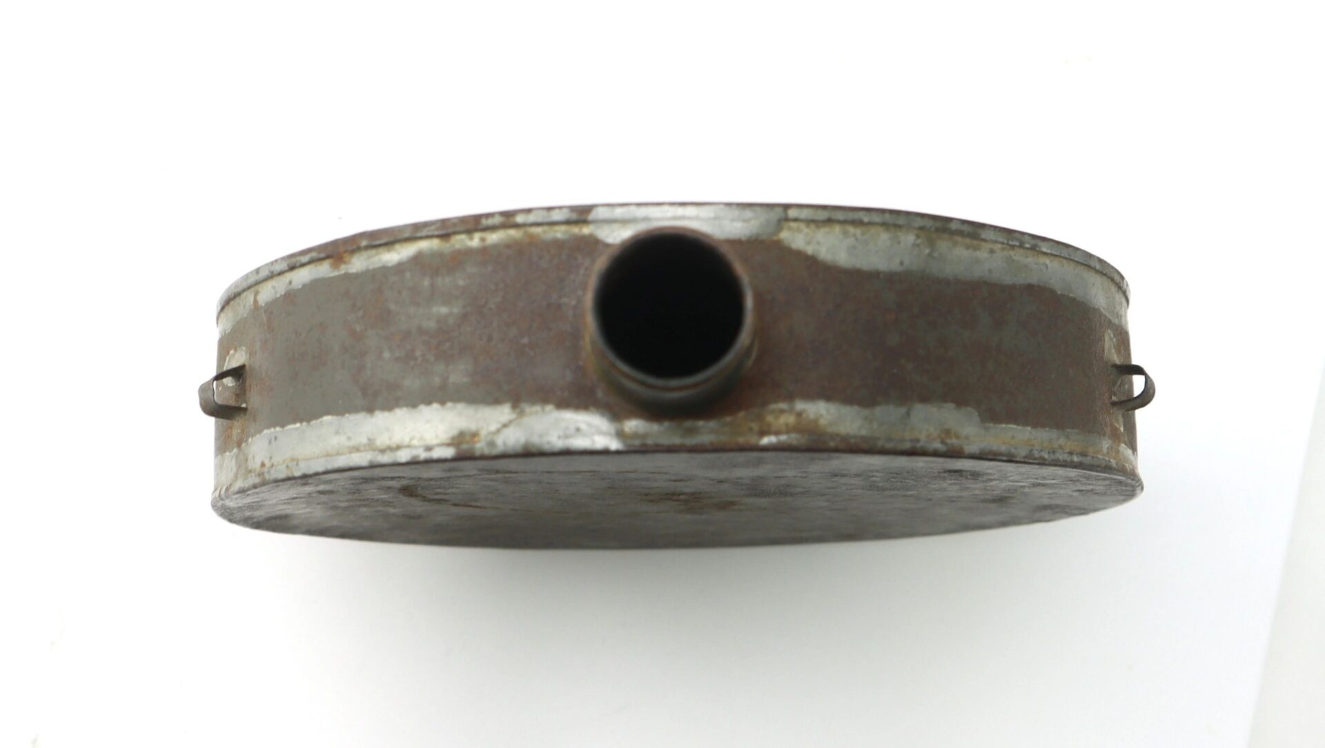A Civil War Tin Drum Canteen—round metal, rusted, with a central spout and two side loops—is photographed on a white background.