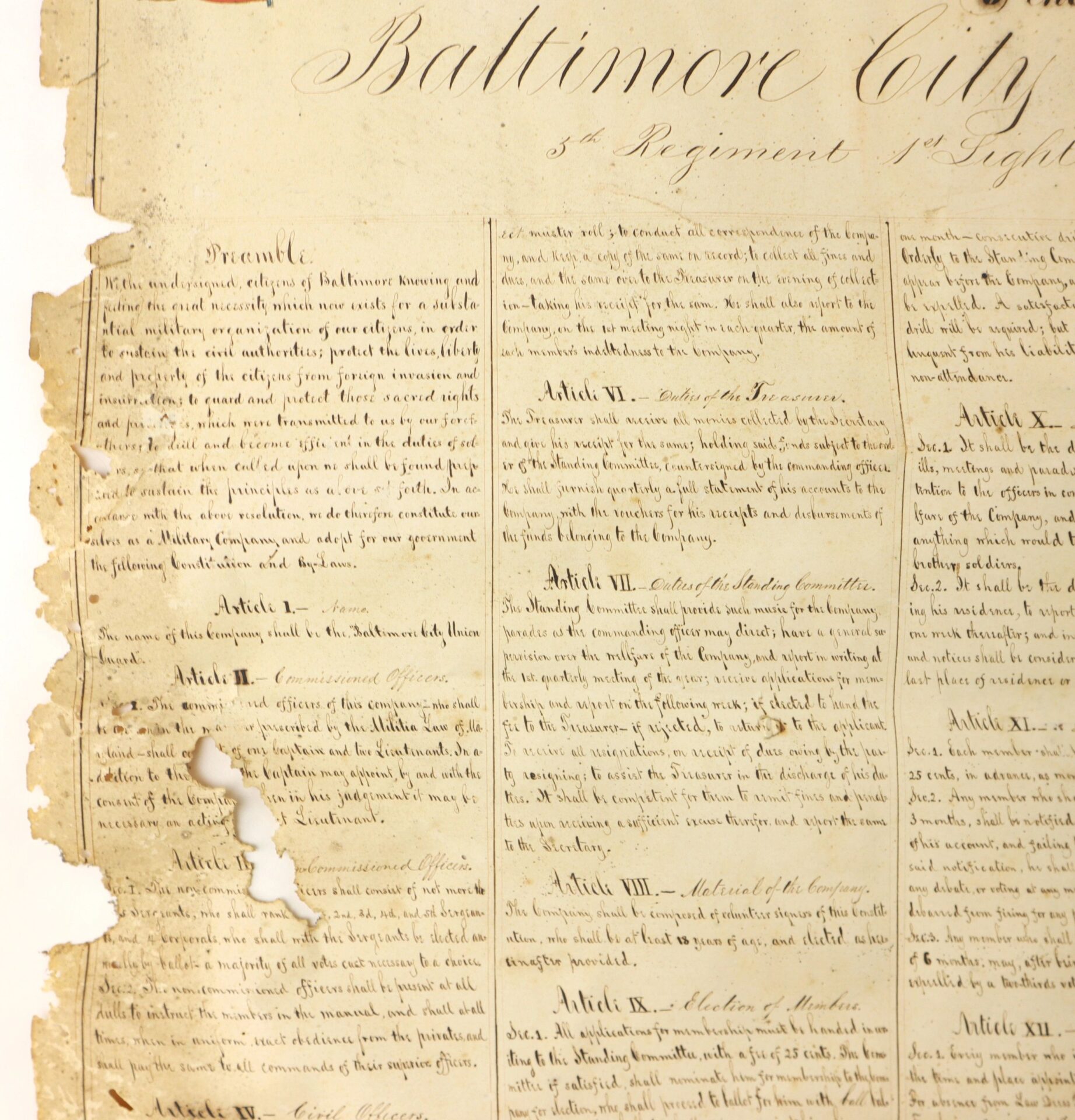 Aged "Constitution and Laws of the Baltimore City Union Guards" (c. 1860s, Baltimore) document with handwritten columns; left edge is torn and burned, displaying notable wear and damage.