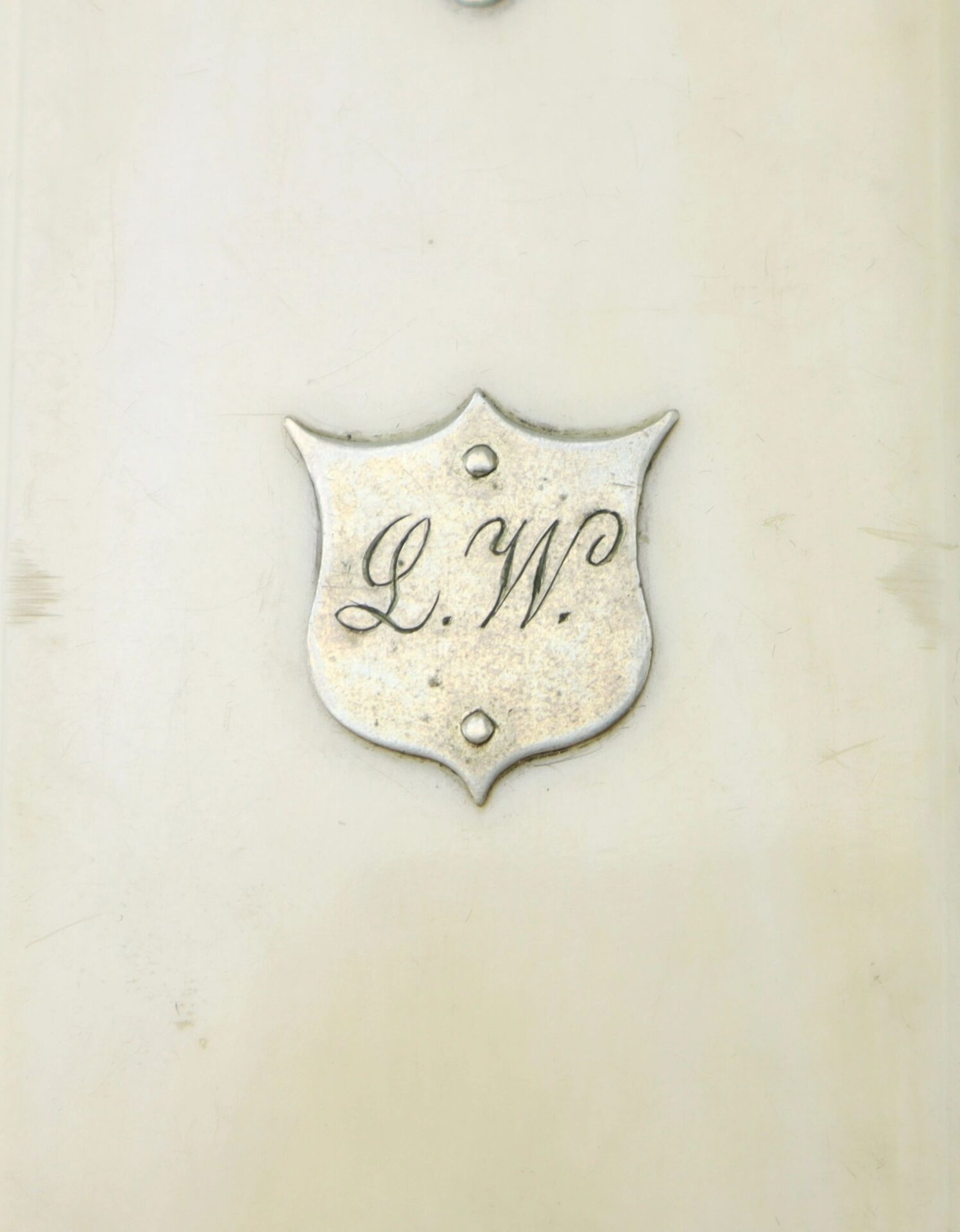 An ivory Charles Weckerle Battery E, 2nd U.S. Light Artillery day planner features a silver shield-shaped plaque engraved with the initials "L.W." attached to its cover.