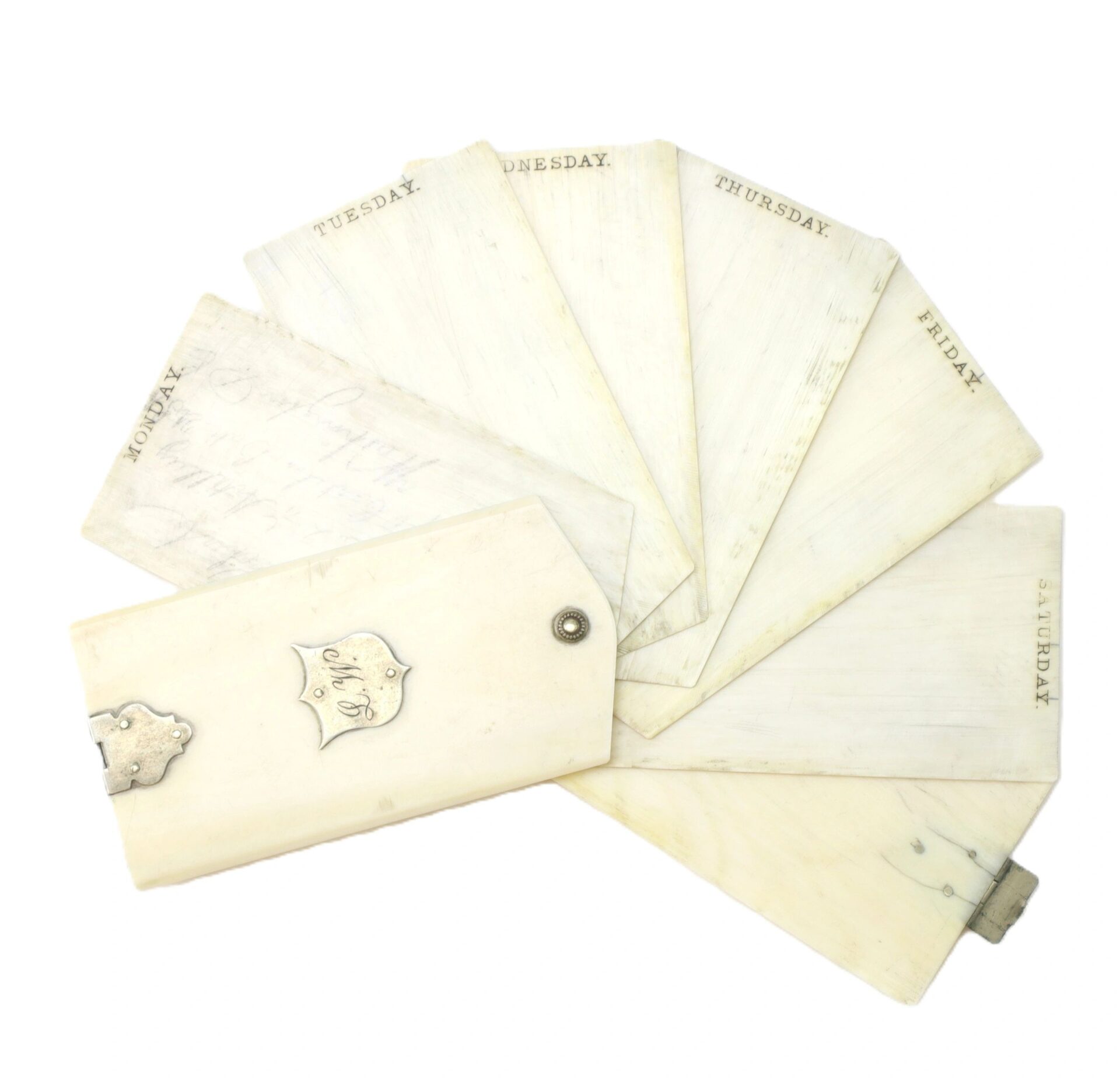The Ivory Day Planner by Charles Weckerle, Battery E, 2nd U.S. Light Artillery, features seven ivory note leaves labeled with days of the week, riveted together and fanned out on a white background.