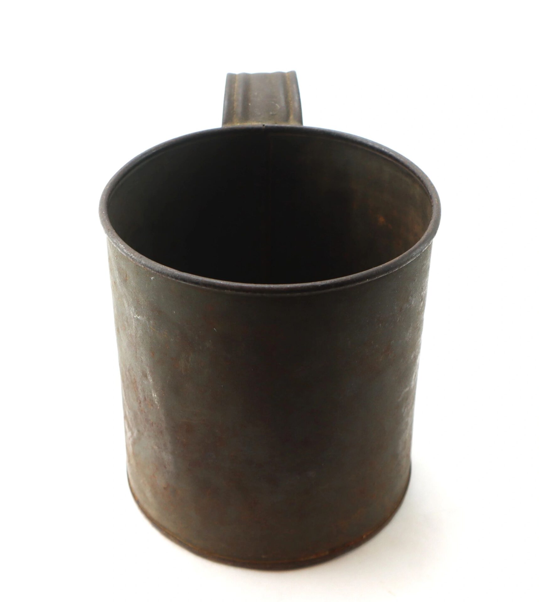 A Civil War Tin Cup with a handle, exhibiting rust and wear, displayed against a plain white background.
