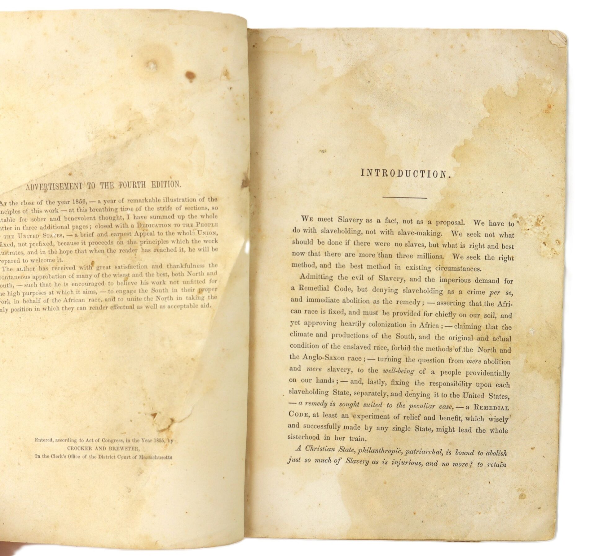 Open to yellowed, stained pages of “Slavery and the Remedy” (1862), 4th Edition by Samuel Nott. Left page, "ADVERTISEMENT TO THE FOURTH EDITION"; right, "INTRODUCTION" discussing slavery. Includes an engraved slave trade print.