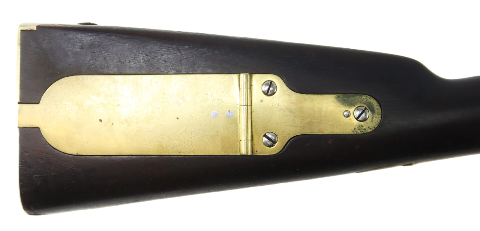 Close-up of a rifle stock with a brass patch box compartment secured by screws.