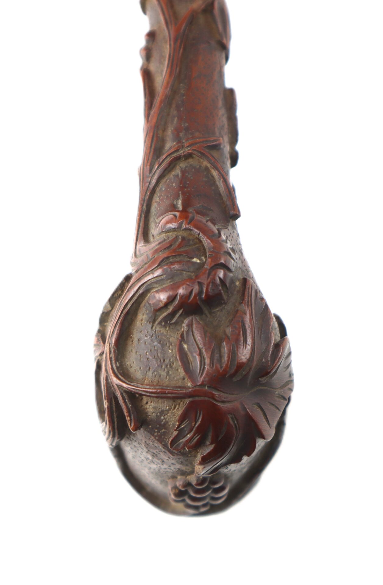 Close-up of a Hand-Carved Civil War-Era Pipe with an intricate grape leaf motif, photographed against a white background.