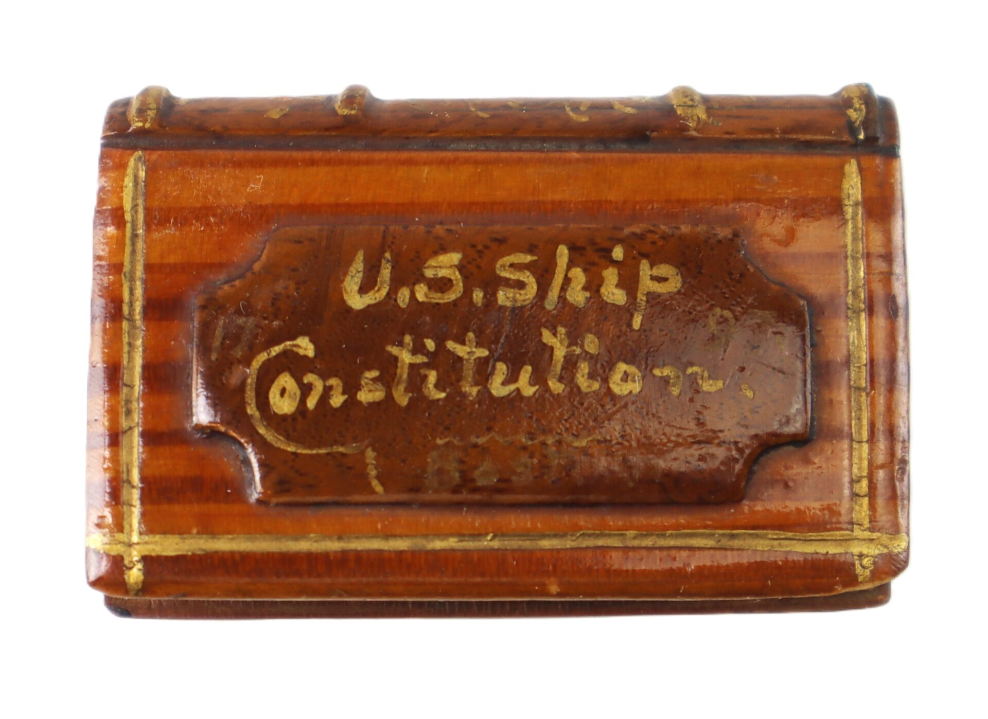A small wooden chest with gold lettering reading "U.S. Ship Constitution" on the lid.