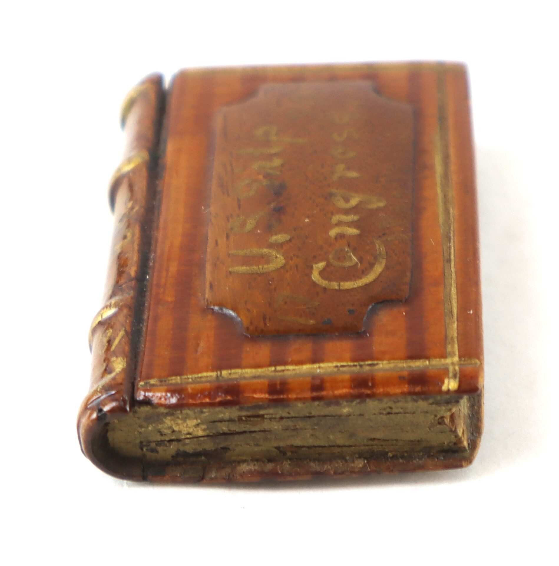 A small, old book with a brown cover, gold-edged pages, and an embossed label reading "U.S. Congress" on the front.