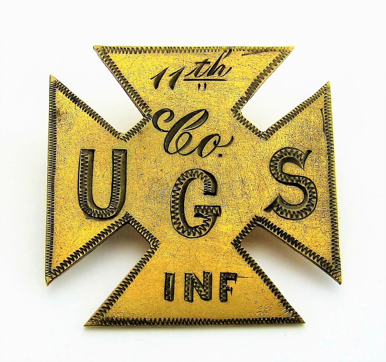 A 11th US Infantry Company G, 5th Corp brass badge with decorative zigzag edges and black engraved lettering.