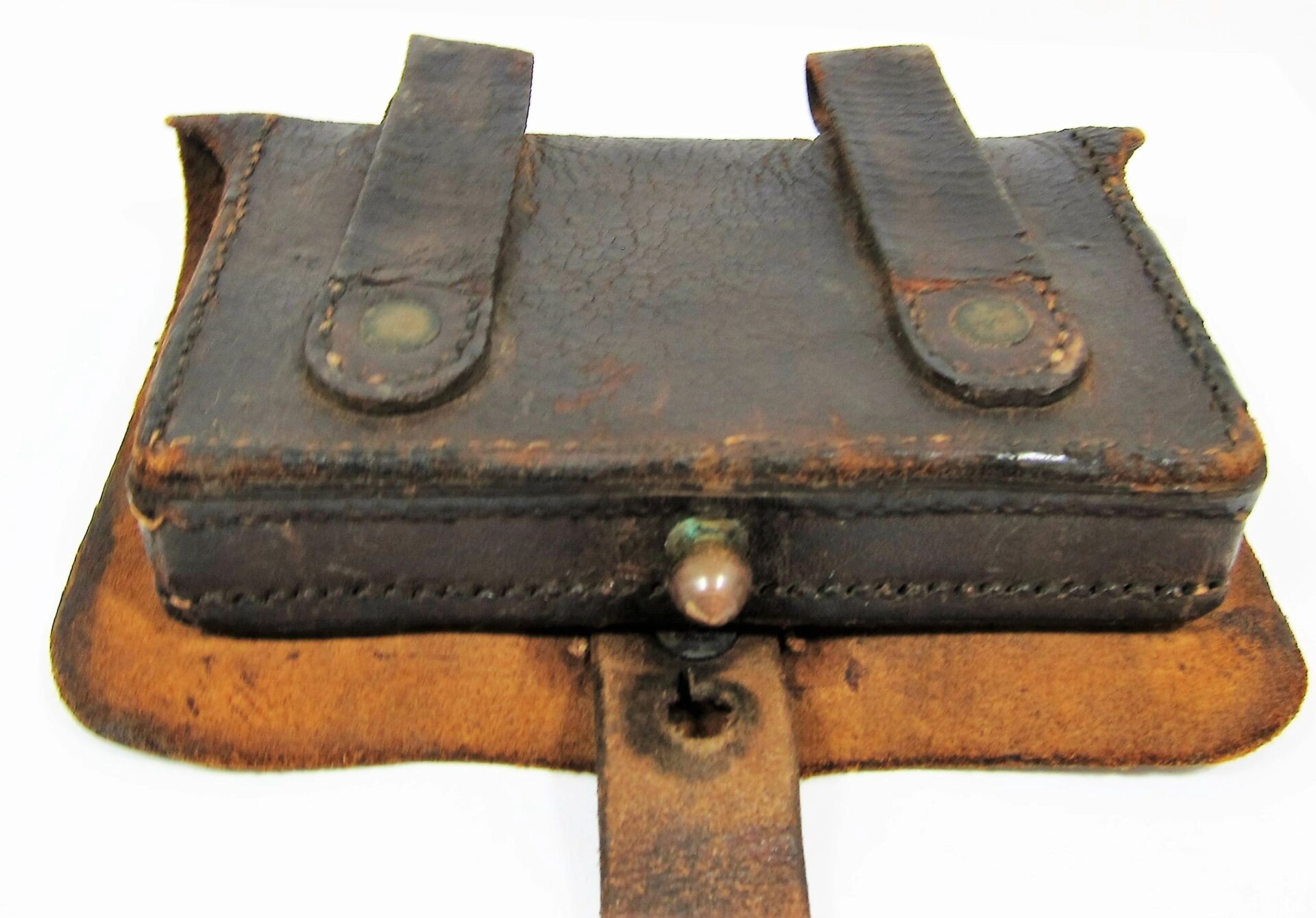 A worn Civil War Pistol Box with a rectangular shape, two belt loops, and a button closure, showing signs of aging and use.