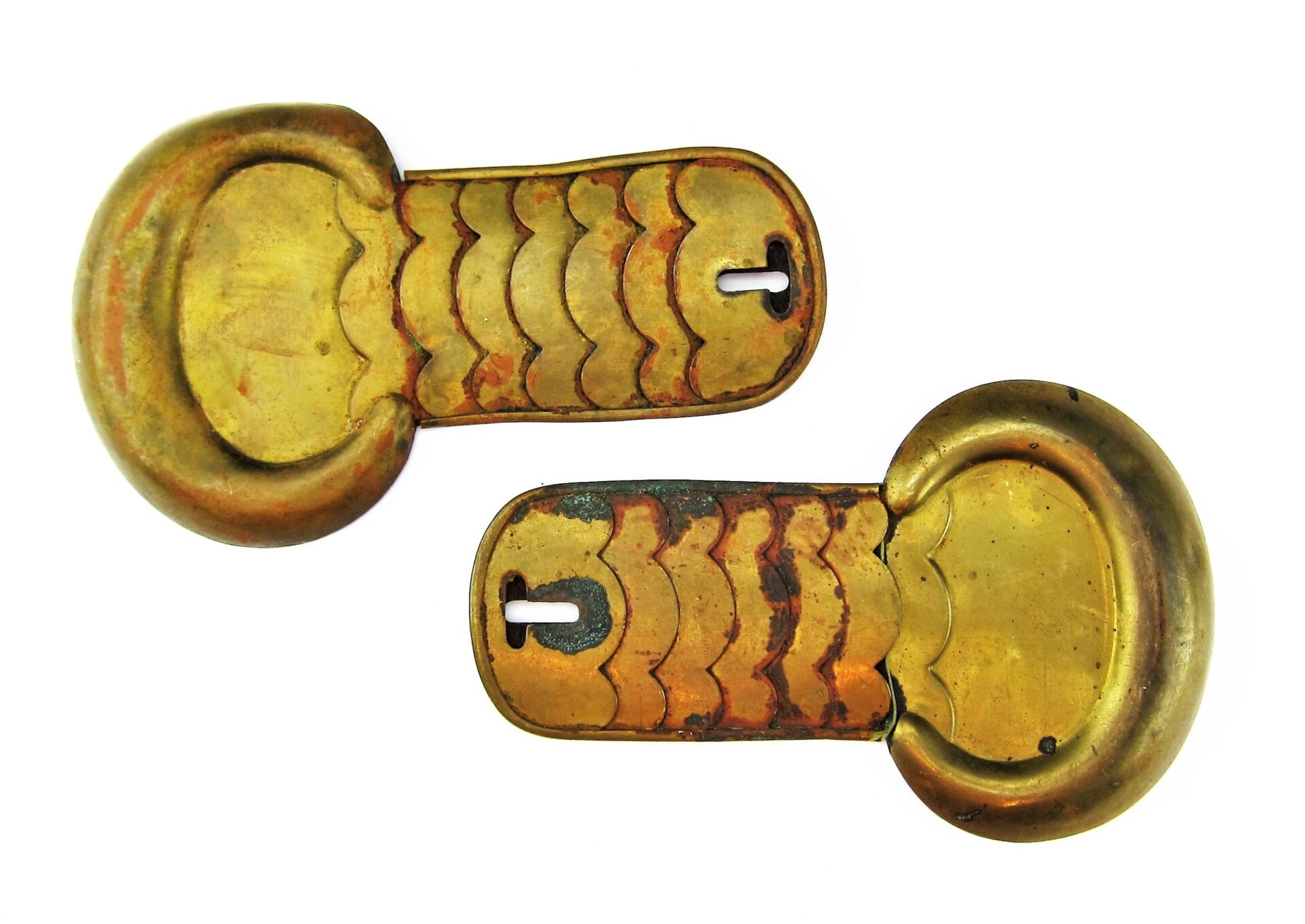 Two Civil War Shoulder Scales with engraved patterns and rounded ends, resembling keyhole-shaped brass objects, are displayed on a white background.