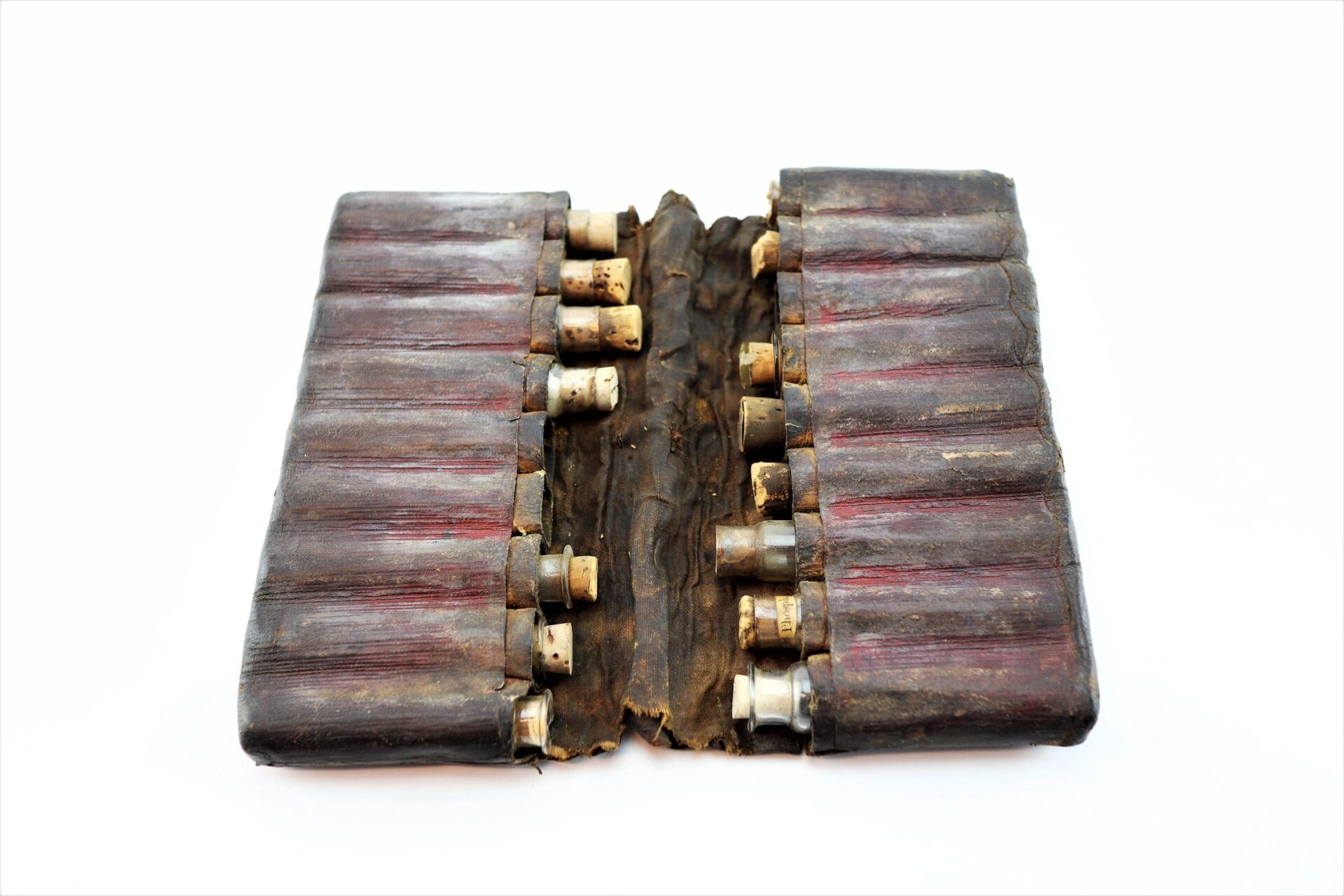 A vintage Leather Apothecary Kit, sold, with multiple compartments and small cylindrical containers, displayed open on a white background.