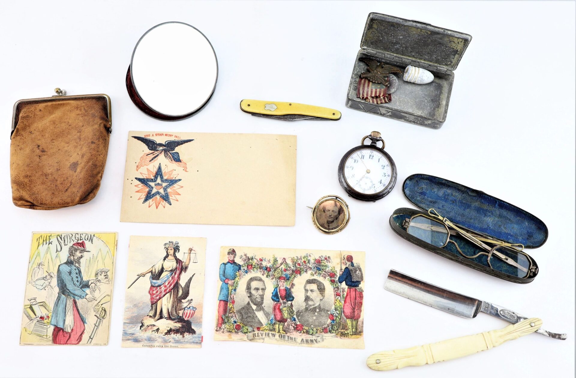 A collection of vintage items from the personal effects of Civil War surgeon Dr. Seth L. Sprague, including postcards, a pocketknife, razor, watch, compact mirror, leather pouch, spectacles, and a small metal box. / SOLD.