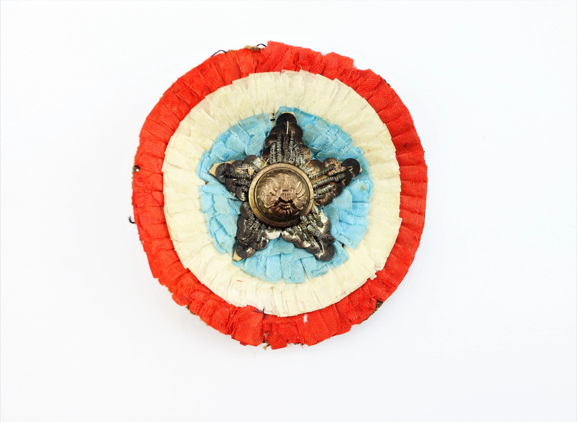The Patriotic Cockade features circular layers of red, white, and blue fabric, accented with a metal star and a central button displaying a relief portrait.