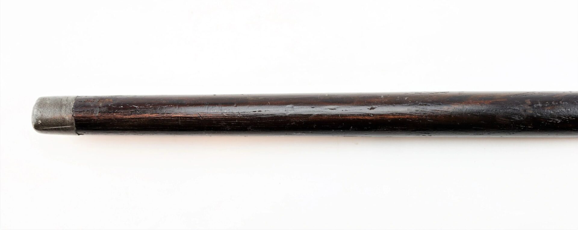 A close-up of the Cane Made From Revolutionary War Battleship, featuring a dark wooden body with a metal cap on one end, set against a white background.