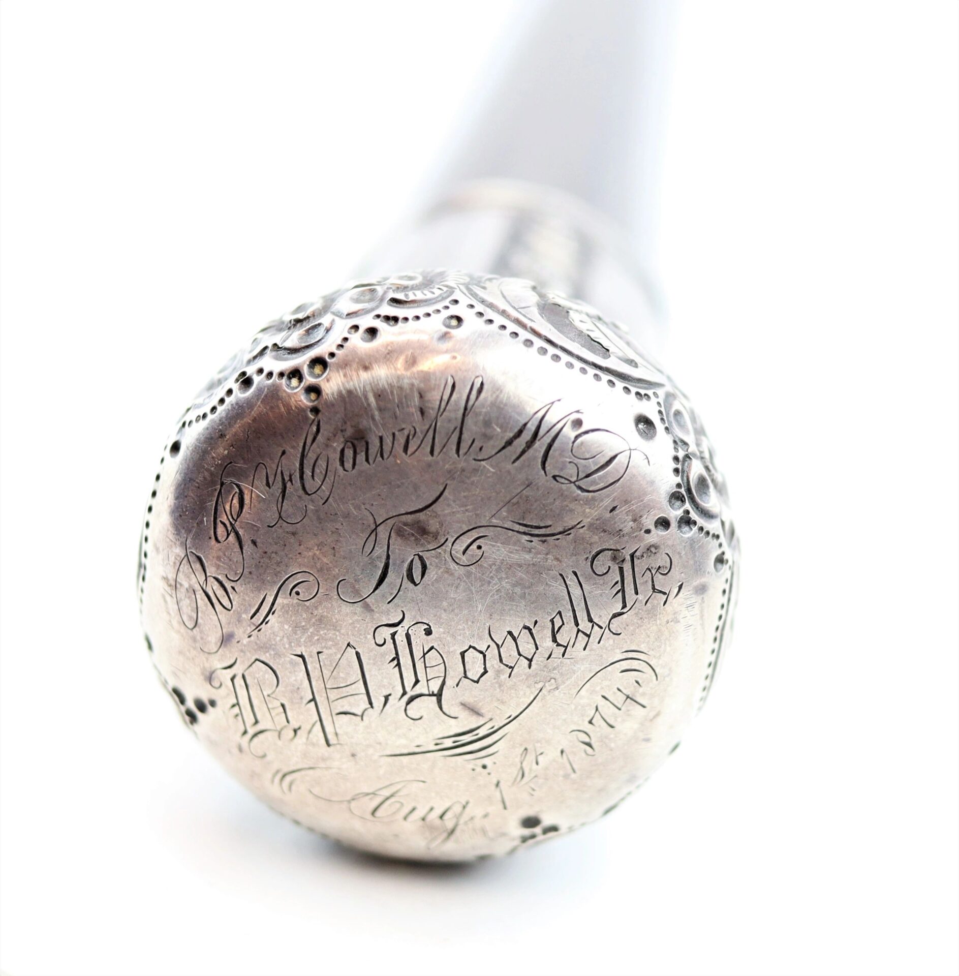 Close-up of a silver handle on the "Cane Made From Revolutionary War Battleship," engraved: "Dr. R. Howell M.D. to B.H. Howell Jr., Aug 1st, 1888," with decorative etching. Sold.