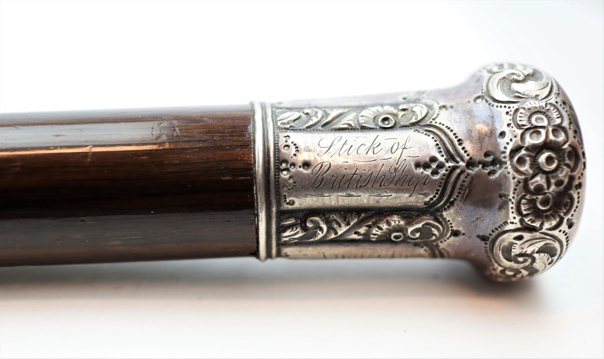 Close-up of a cane made from Revolutionary War battleship wood, featuring a decorative silver handle.