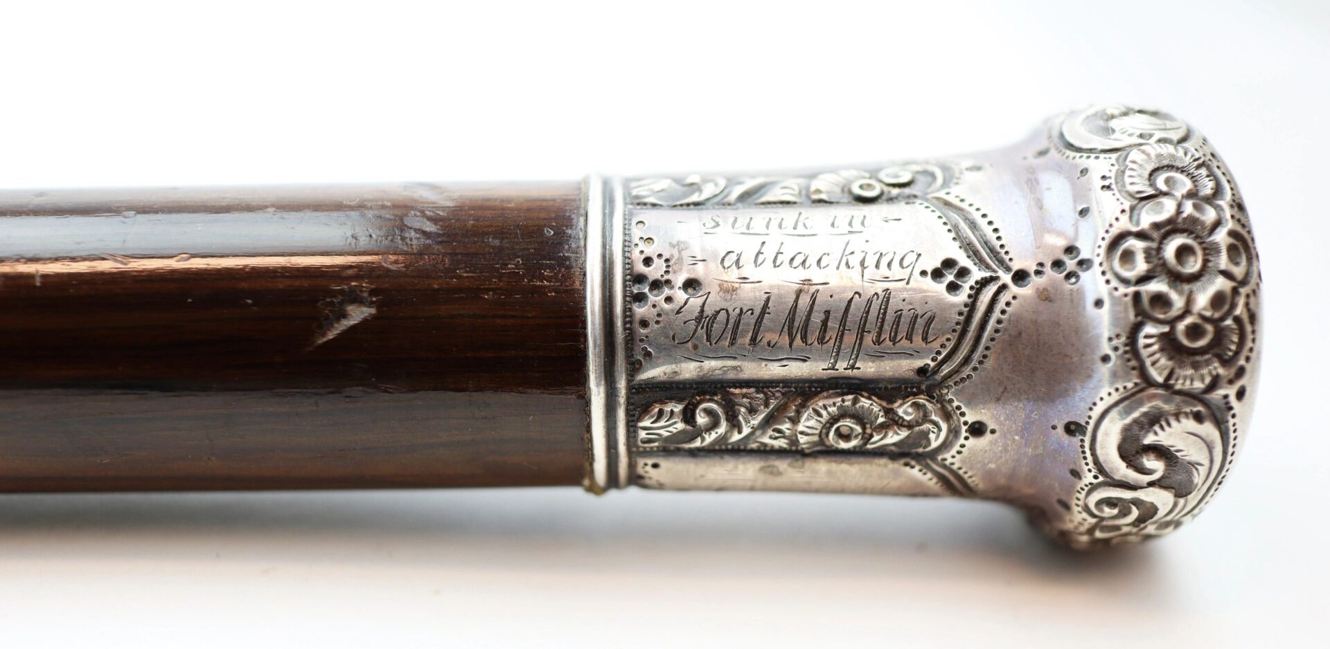 Close-up of a Cane Made From Revolutionary War Battleship, featuring an ornate silver handle engraved with "Sunk in attacking Fort Mifflin.