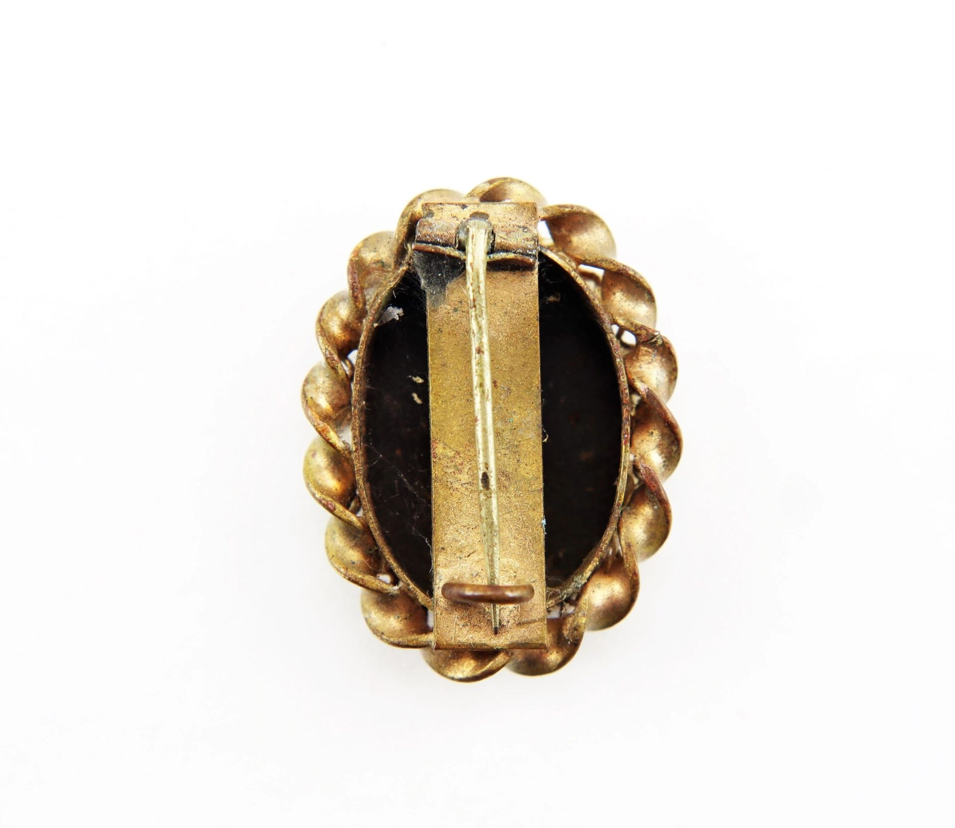 The Civil War Brooch / SOLD features a gold-toned oval design with scalloped edges, shown from the back to display its horizontal clasp and pin mechanism.