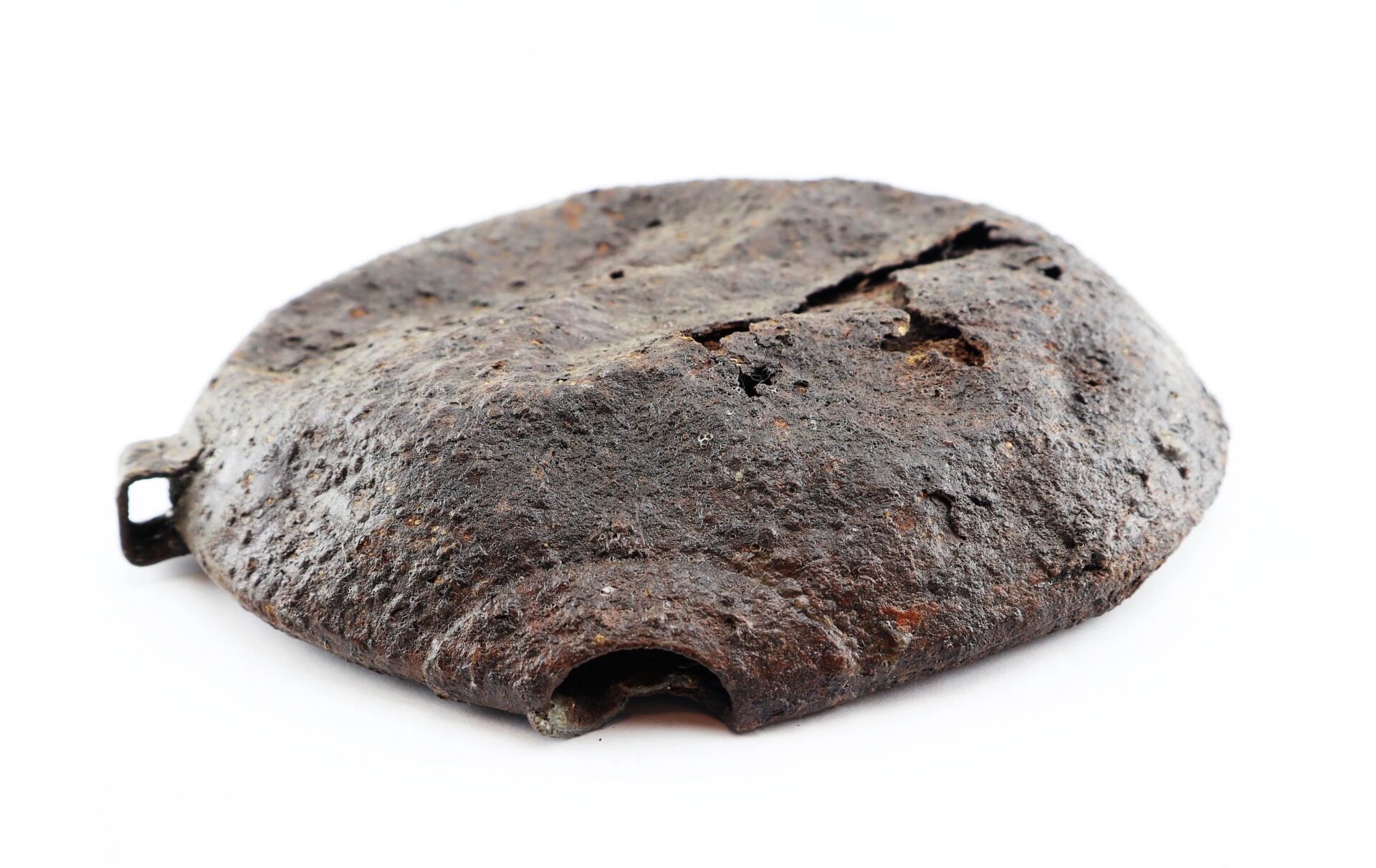 A rusted, cracked, circular metal Battlefield Relic Canteen with a small rectangular protrusion and an opening is shown on a white background. / Sold.