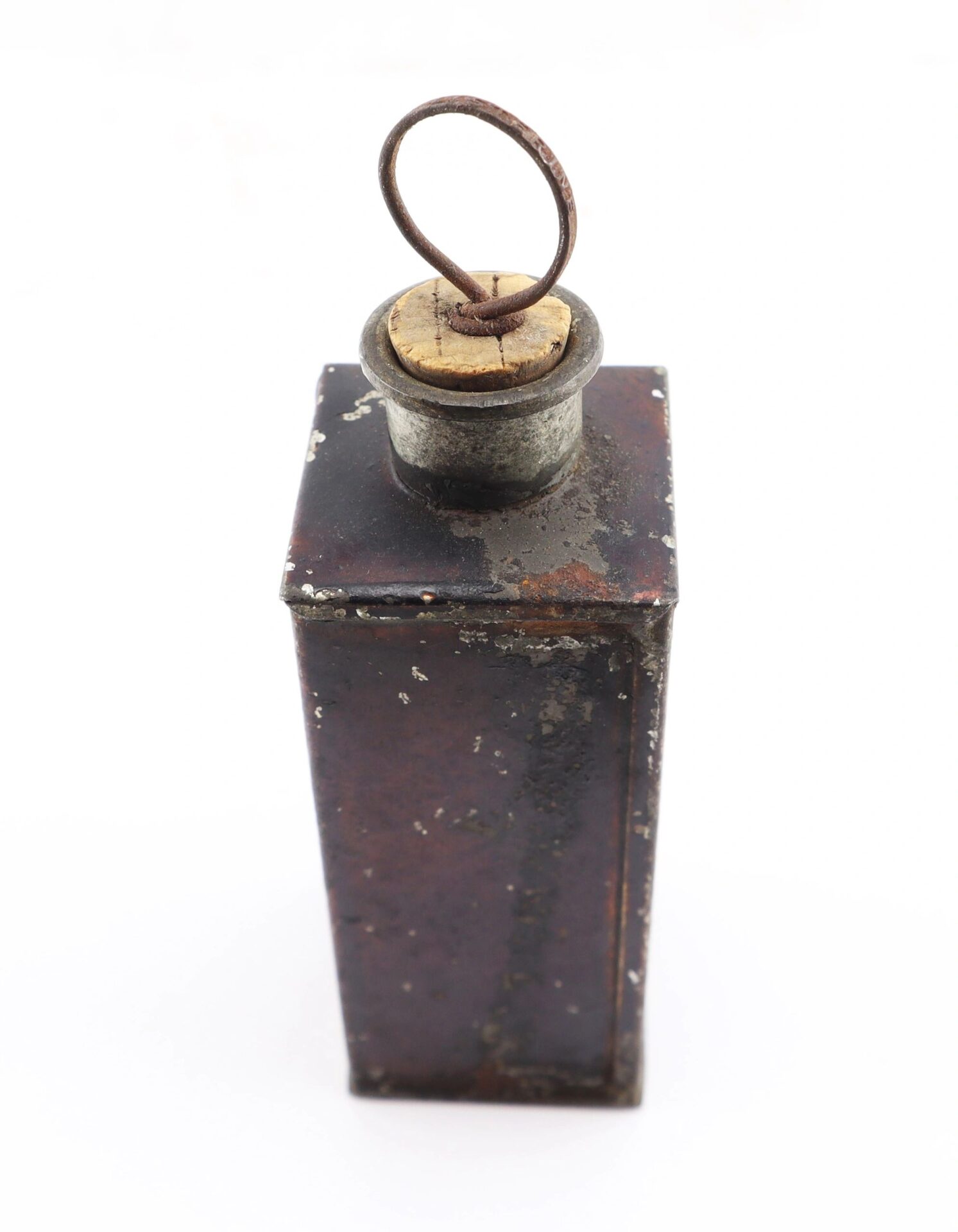 A Civil War Medical Tin, rectangular with a worn surface, cork stopper, and circular wire handle on top, viewed from above.