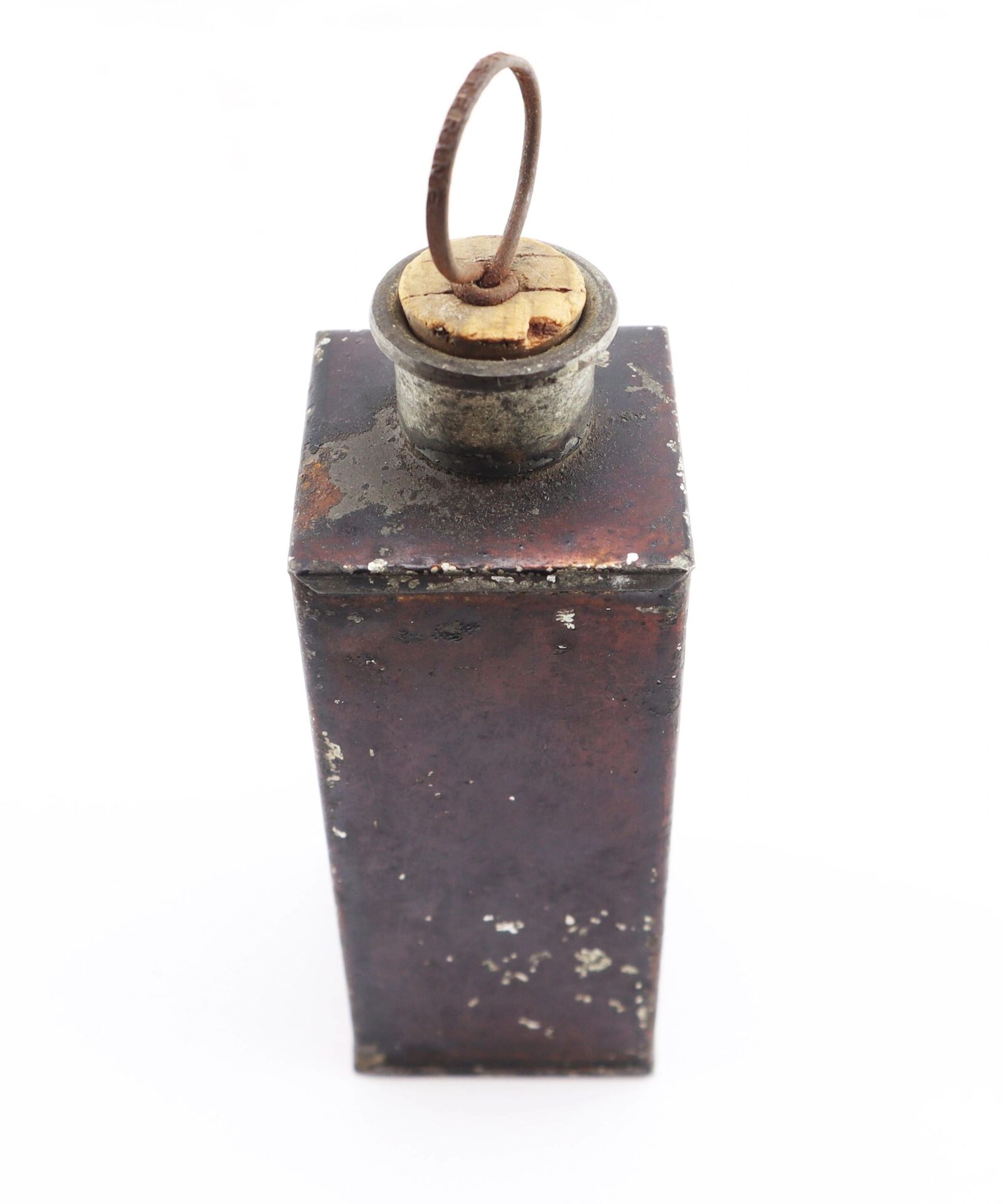A Civil War Medical Tin—rectangular metal container with a cork stopper and metal loop—shows wear and corrosion.