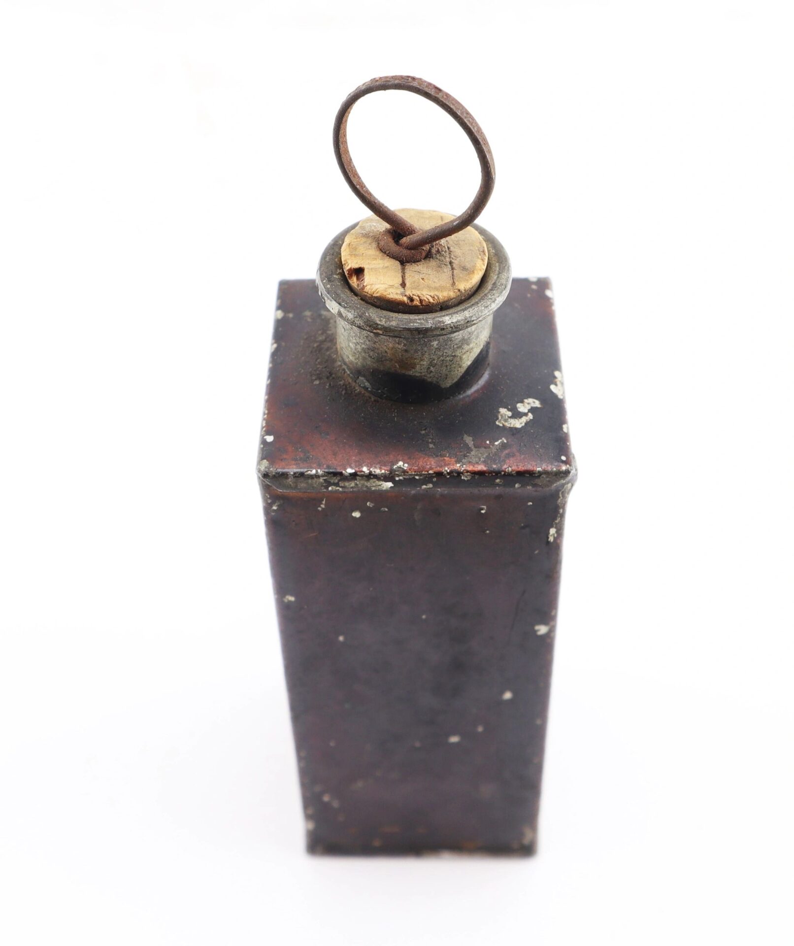 The Civil War Medical Tin, featuring a rectangular metal body with a cork stopper and metal ring, displays visible age and wear on its surface.