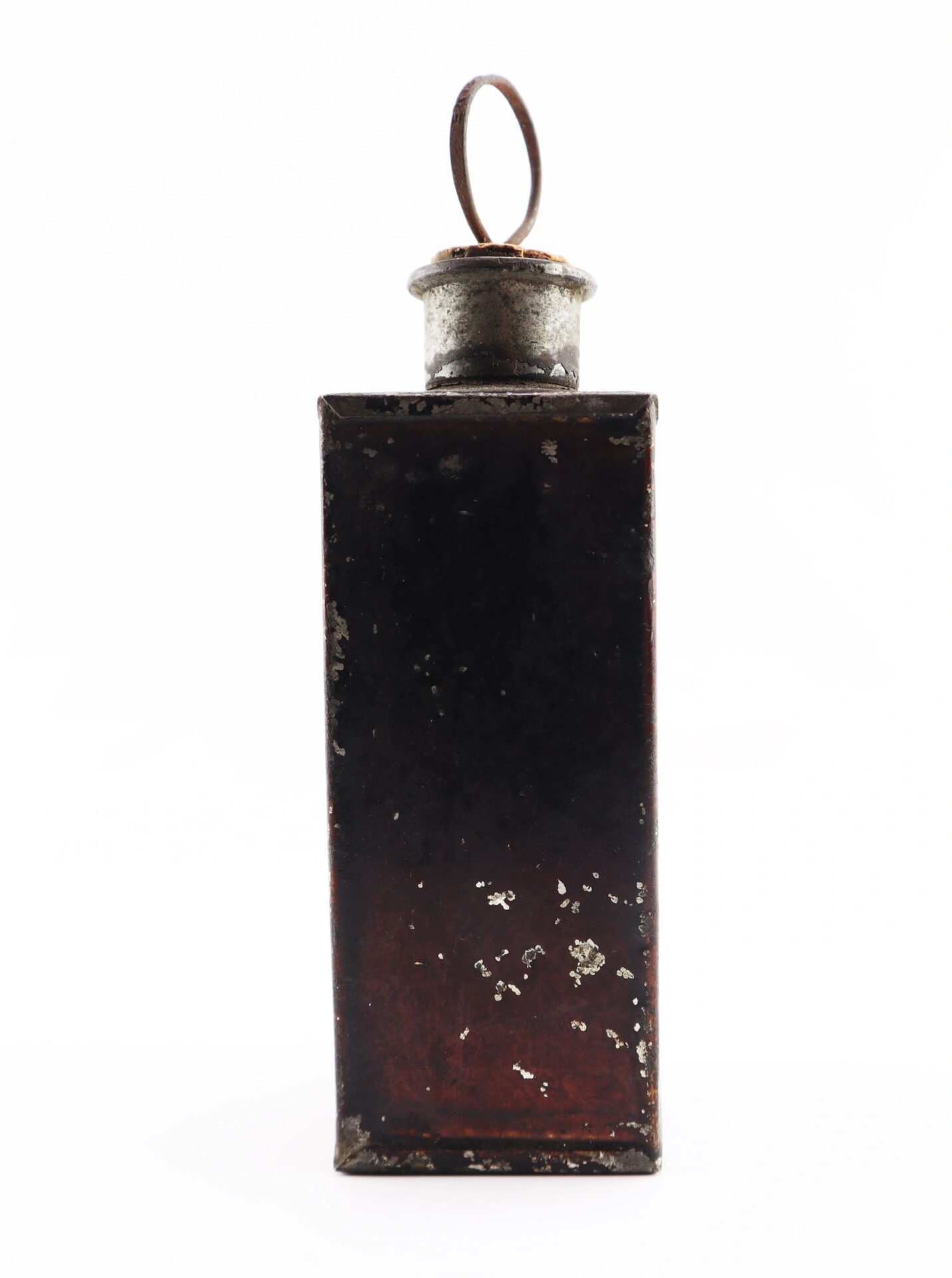 A Civil War Medical Tin with a rectangular, weathered metal body, round rusted cap, and loop handle on top is shown against a white background.